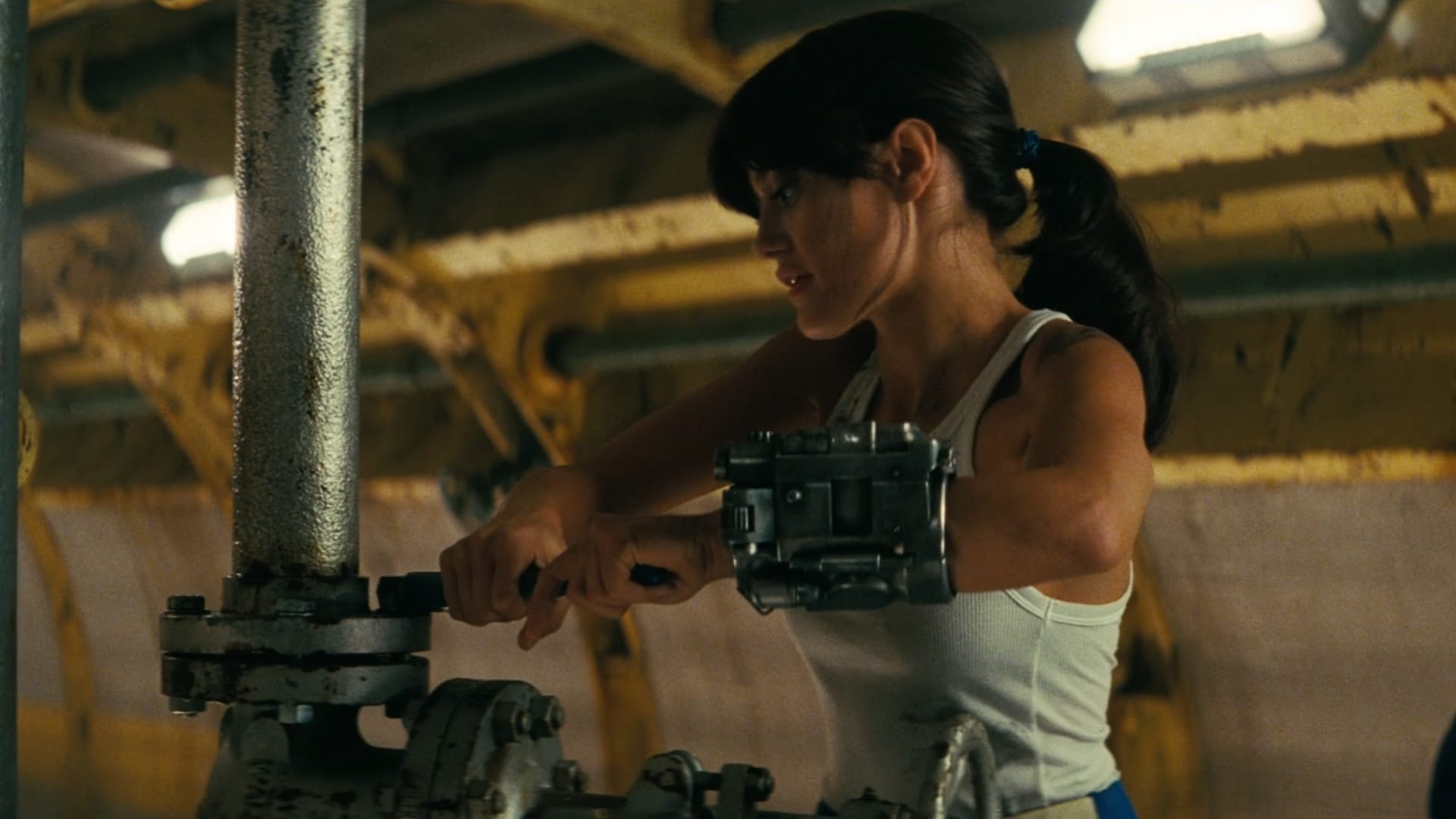 Lucy, giant metal Pip-Boy on her left arm, uses a big wrench to tighten a bolt on some silver vertically-oriented tubing. she is in a tank top with a ponytail now.